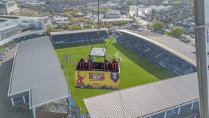 Four lucky football fans were hoisted 50 metres to enjoy the football drink in hand